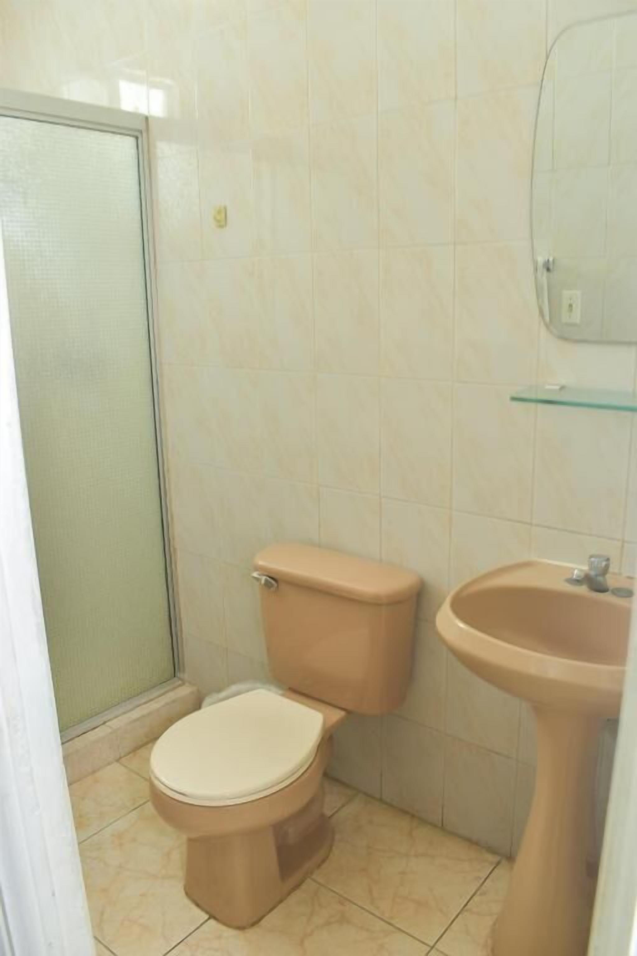 Un baño con inodoro, lavabo y ducha.