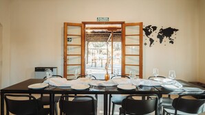 Een eetruimte met een tafel voor zes personen, een wereldkaart aan de muur en een bordje met een vluchtroute.