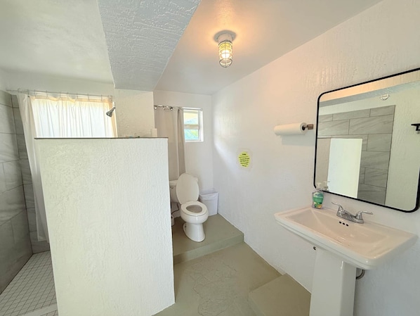 A bathroom with a toilet, sink, and shower area. - Southern Cross 40 ft 1977 Marine Trader | Free Kayaks (Monroe County)