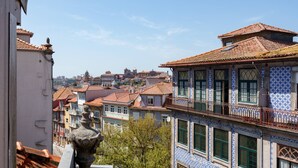 Une vue sur un paysage urbain avec des bâtiments traditionnels, dont un bâtiment orné de carreaux bleus et blancs et doté d’un balcon avec une balustrade en fer forgé.