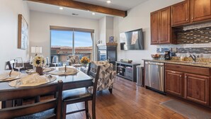 Una cocina amplia con armarios de madera, lavavajillas de acero inoxidable y un ventanal con vistas al exterior.