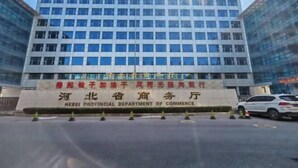 Un edificio de varios pisos con un cartel que indica que es la Oficina Provincial de Comercio de Hebei.