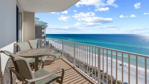 A balcony with a view of the beach and ocean.