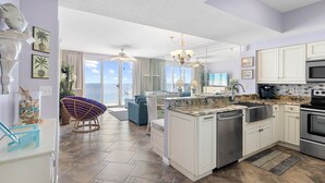 A modern kitchen with white cabinetry, a granite countertop, and stainless steel appliances.