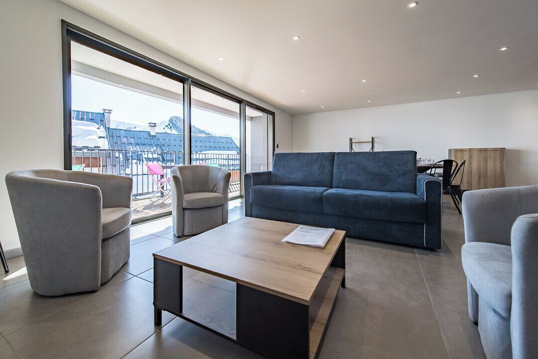 A modern living room with a sofa, chairs, and a coffee table.