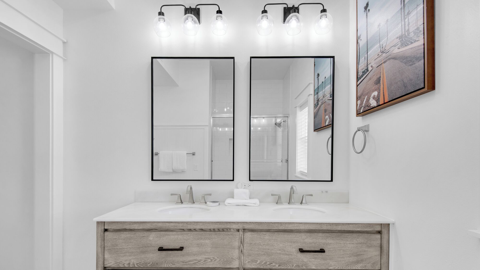 Une salle de bain moderne avec deux lavabos, un grand miroir et un meuble-lavabo en bois.