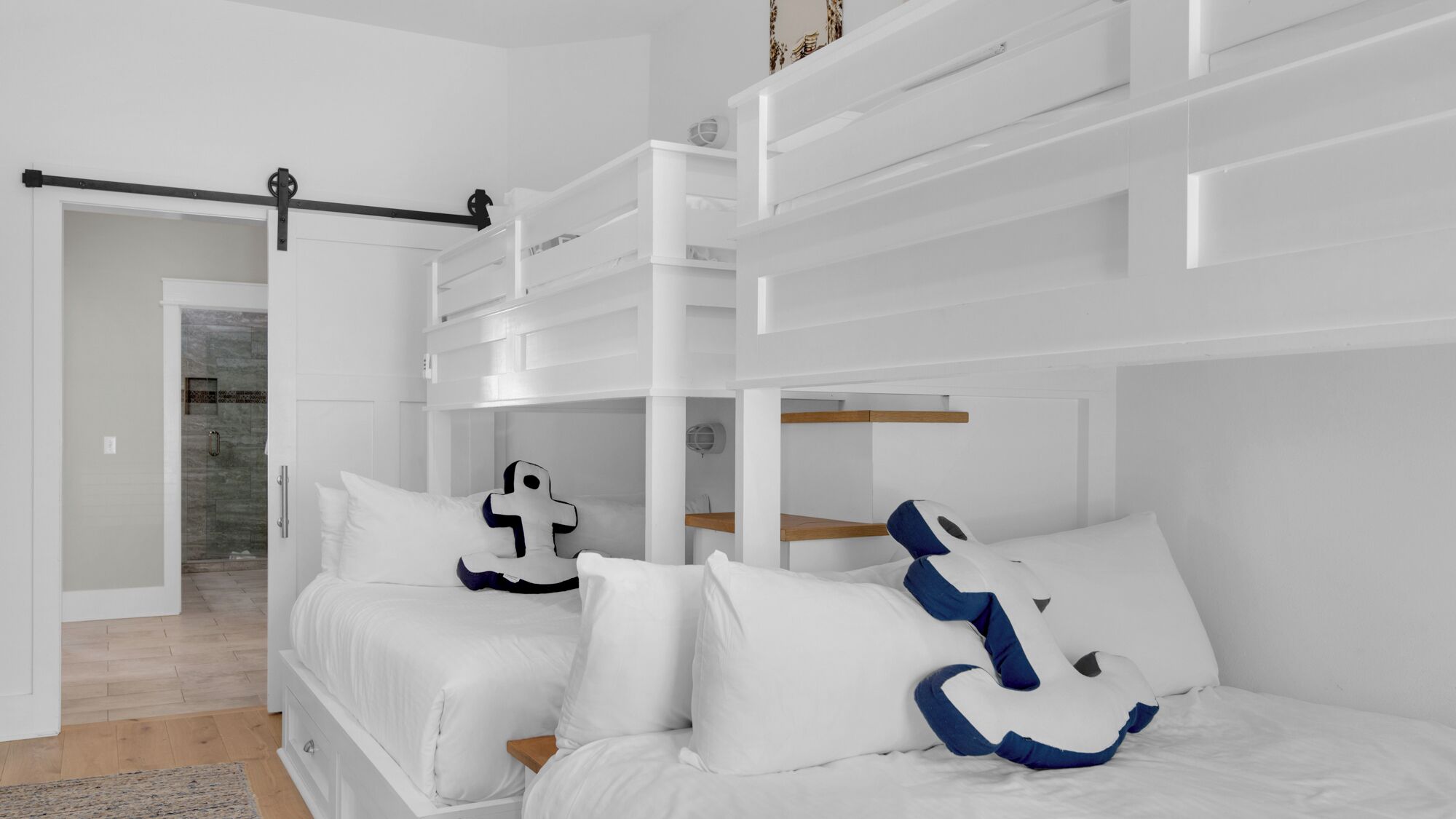 Ein modernes Schlafzimmer mit Etagenbett, klappbarem Schreibtisch und Dusche.