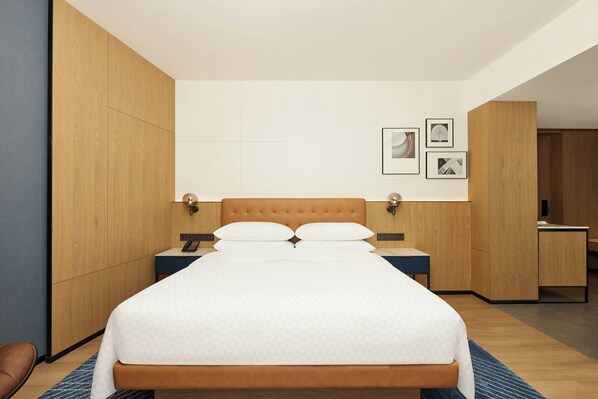 A modern hotel room with a large bed, wooden wardrobe, bedside tables, and framed pictures on the wall. - Four Points By Sheraton Kunming Dongfeng Square (Kunming)