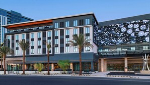 A hotel with a modern facade, palm trees, and a distinctive wall with circular patterns. - AC Hotel by Marriott Las Vegas Symphony Park (Las Vegas)