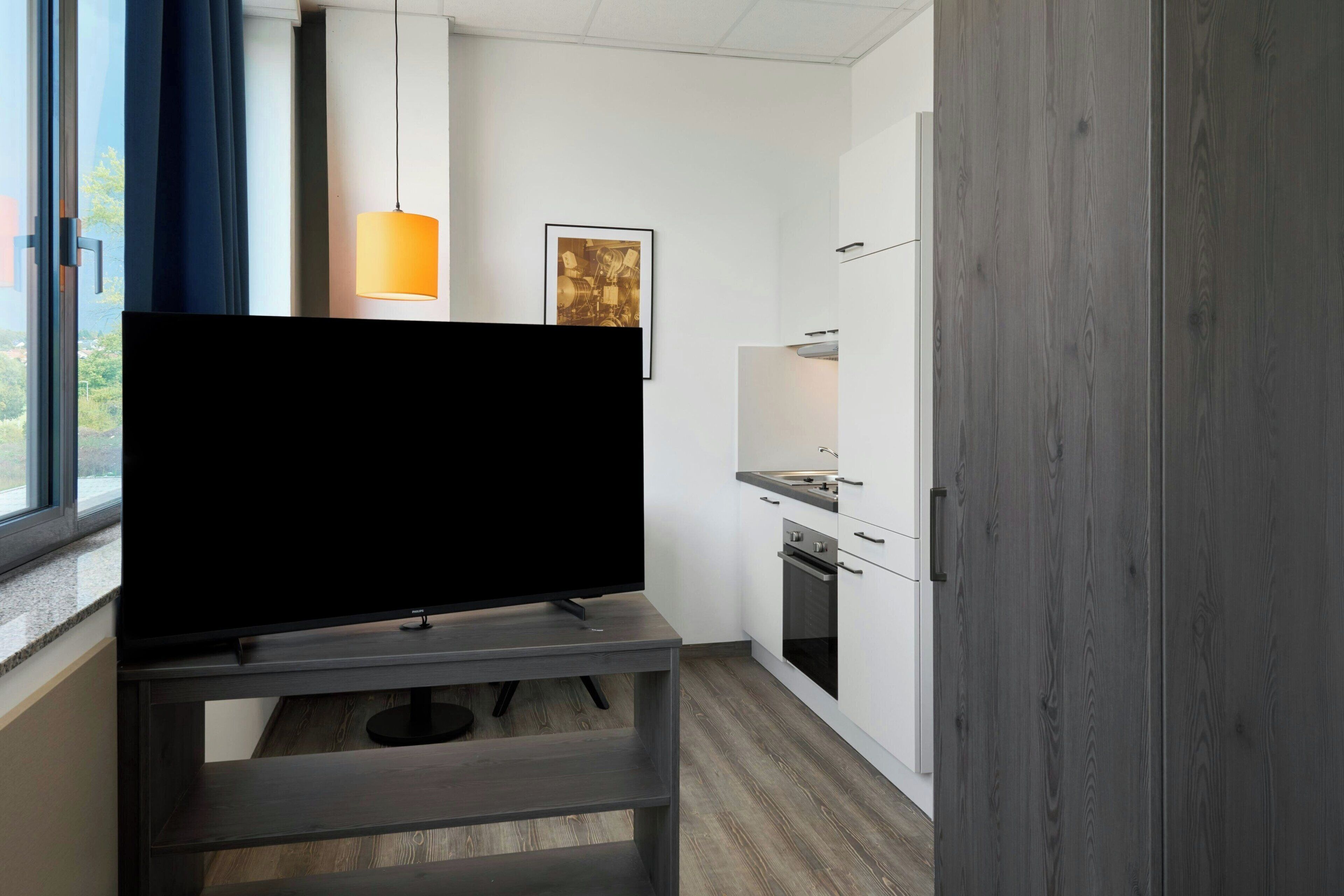 A modern kitchen with a built-in oven, a microwave, and a sink.