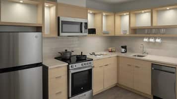 A modern kitchen with a stainless steel refrigerator, a built-in oven, a microwave, and a sink.