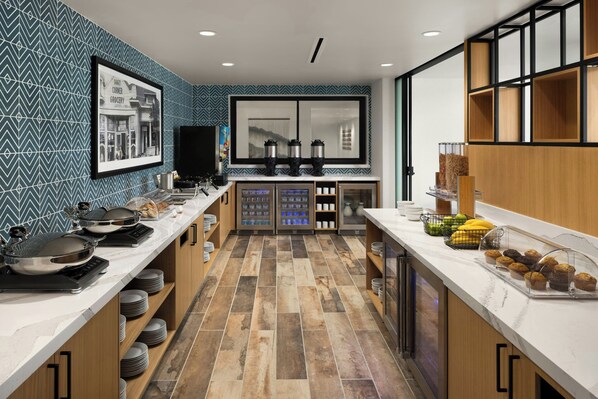 A modern kitchen with a long counter, a large window, and a wall-mounted coffee machine. - Towneplace Suites By Marriott San Jose Downtown (San Jose)