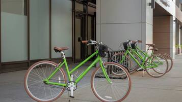 A row of bicycles parked outside a building with a modern architectural design.