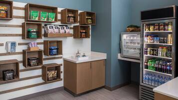 Una kitchenette con estantes de madera, un refrigerador y un lavabo.