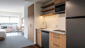A modern kitchen with wooden cabinets, a stainless steel refrigerator, and a built-in dishwasher.