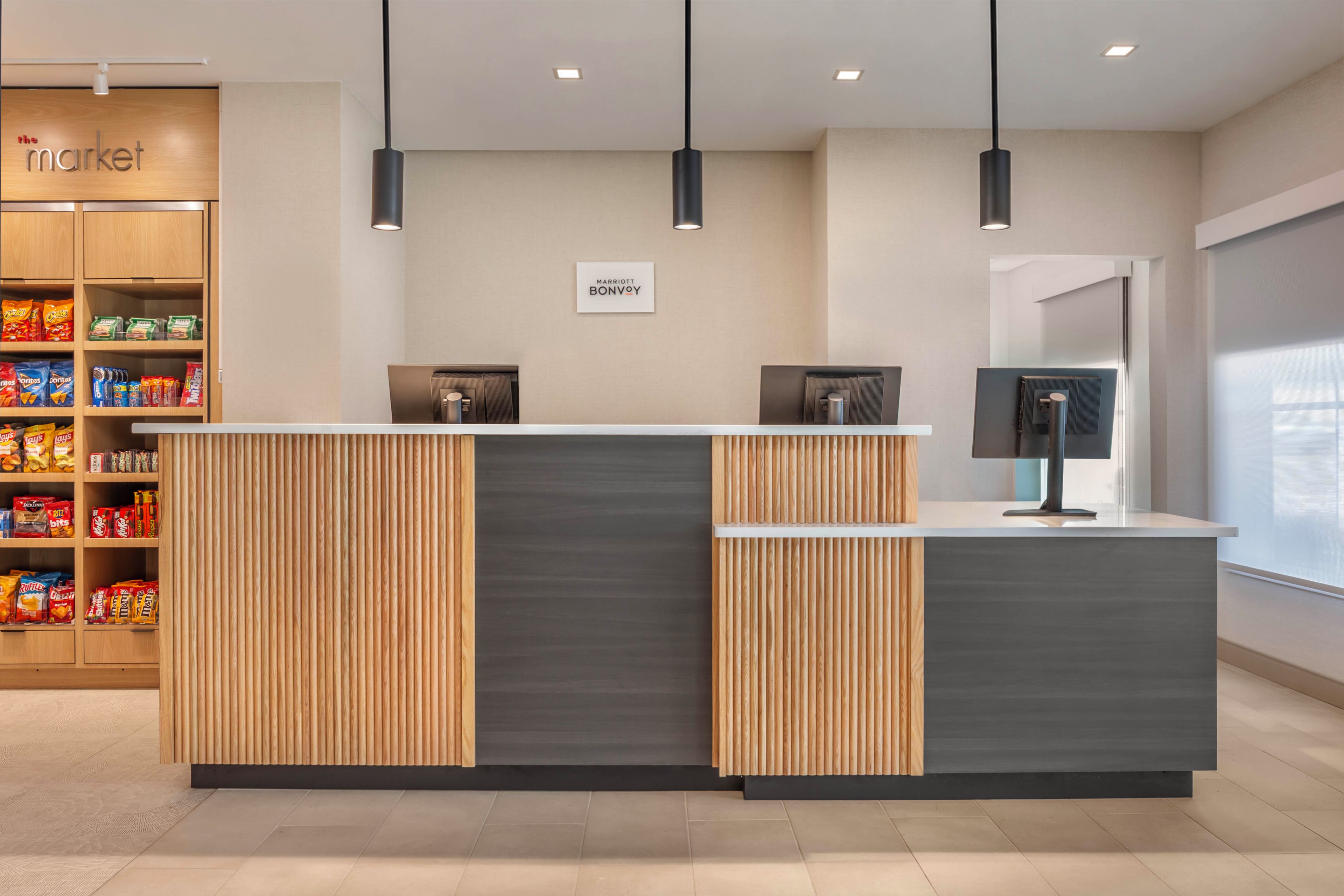 En moderne hotelreception med træpanel og en grå disk.