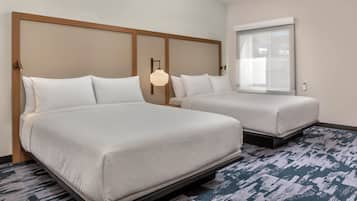A hotel room with two beds, a large window, and a modern light fixture.