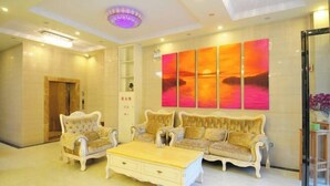 A spacious living room with a large painting, a sofa set, and a coffee table.