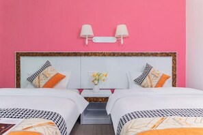 Ein Doppelbett mit weißem Kopfteil, zwei Nachttischlampen und Zierkissen.