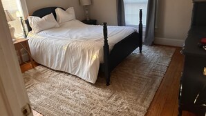A bedroom with a bed, nightstand, lamp, and dresser. - Holmes Residence (Taylorsville)