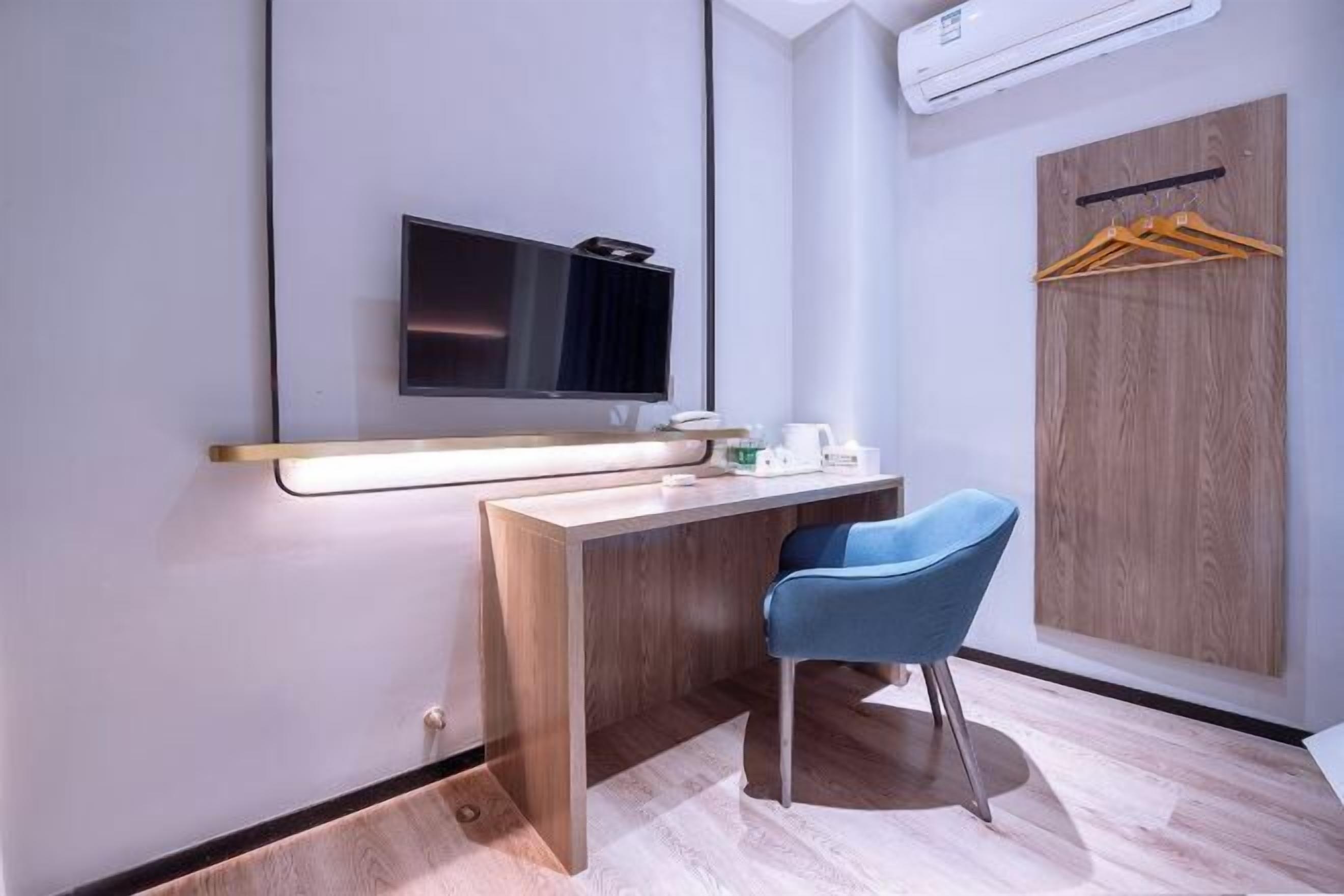 A modern bathroom with a wooden vanity, a mirror, a sink, and a blue chair.
