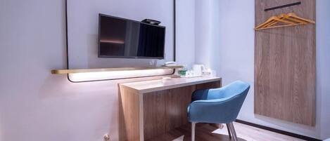 A modern bathroom with a wooden vanity, a mirror, a sink, and a blue chair.