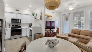A modern kitchen with white cabinets, a microwave, stove, and a dining area with a marble table and chairs. - 3br/2ba, Sleeps 6, BBQ Grill, Pool, Beach Access + Free Attraction Tickets! (Santa Rosa Beach)
