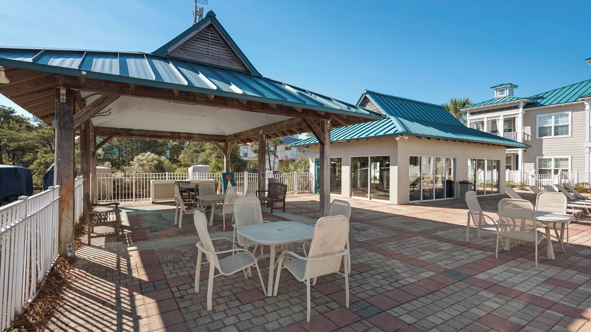 Eine überdachte Terrasse im Freien mit Sitzgelegenheiten und Grillbereich.