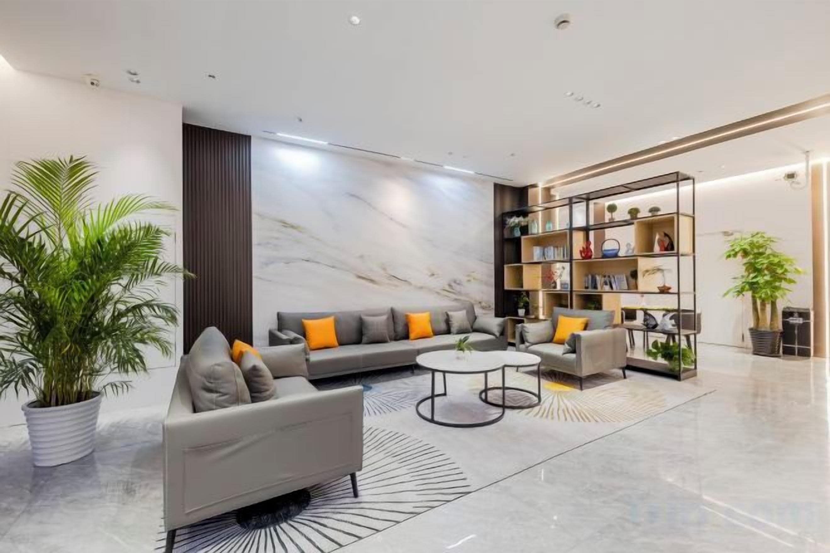 A modern living room with a sofa, coffee table, and a bookshelf.