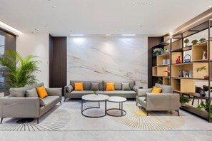 A modern living room with a sofa set, coffee tables, and a bookshelf. - Wanfenglin Hotel (Shanghai Heqing Meijiayi Plaza Branch) (Shanghai)