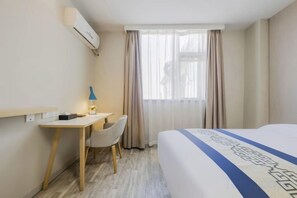 A hotel room with a bed, a desk, a chair, and a window with curtains. - Wanfenglin Hotel (Shanghai Heqing Meijiayi Plaza Branch) (Shanghai)