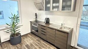 A modern kitchen with a built-in oven, a coffee maker, and a sink.