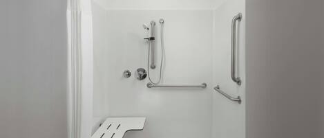 Een moderne douche met een handgreep, een douchekop die je kunt vasthouden en een antislipmat.