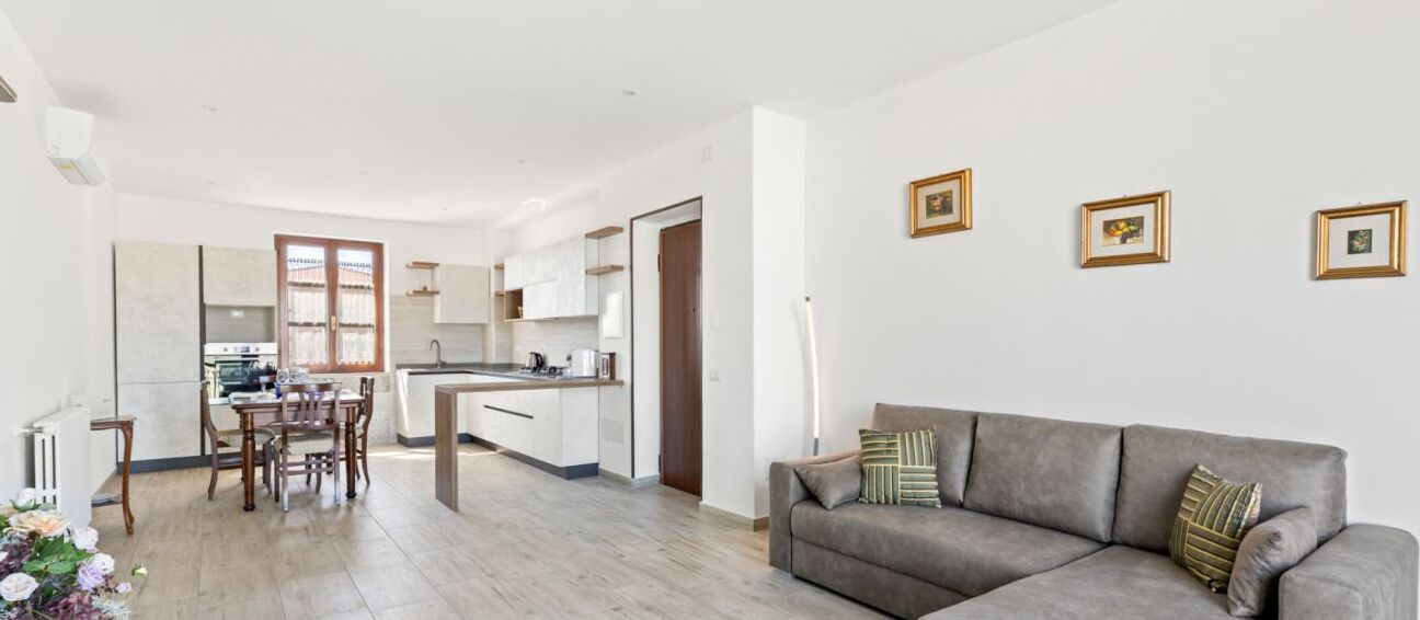 A modern apartment with a dining area, kitchen, and living room.