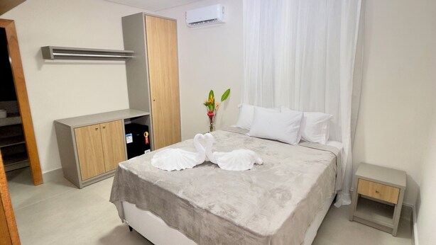 Une chambre bien rangée, avec un lit, une table de chevet et une armoire.