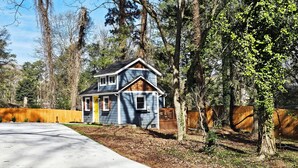A two-story house with a front yard and a driveway. - Private Atlanta Tiny House with 
Mini Golf Course (Forest Park)