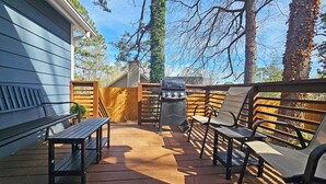 A patio with a barbecue grill, wooden furniture, and a wooden fence. - Private Atlanta Tiny House with 
Mini Golf Course (Forest Park)