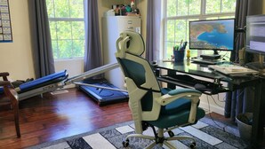 Una oficina en casa con escritorio, computadora y equipo de ejercicio.