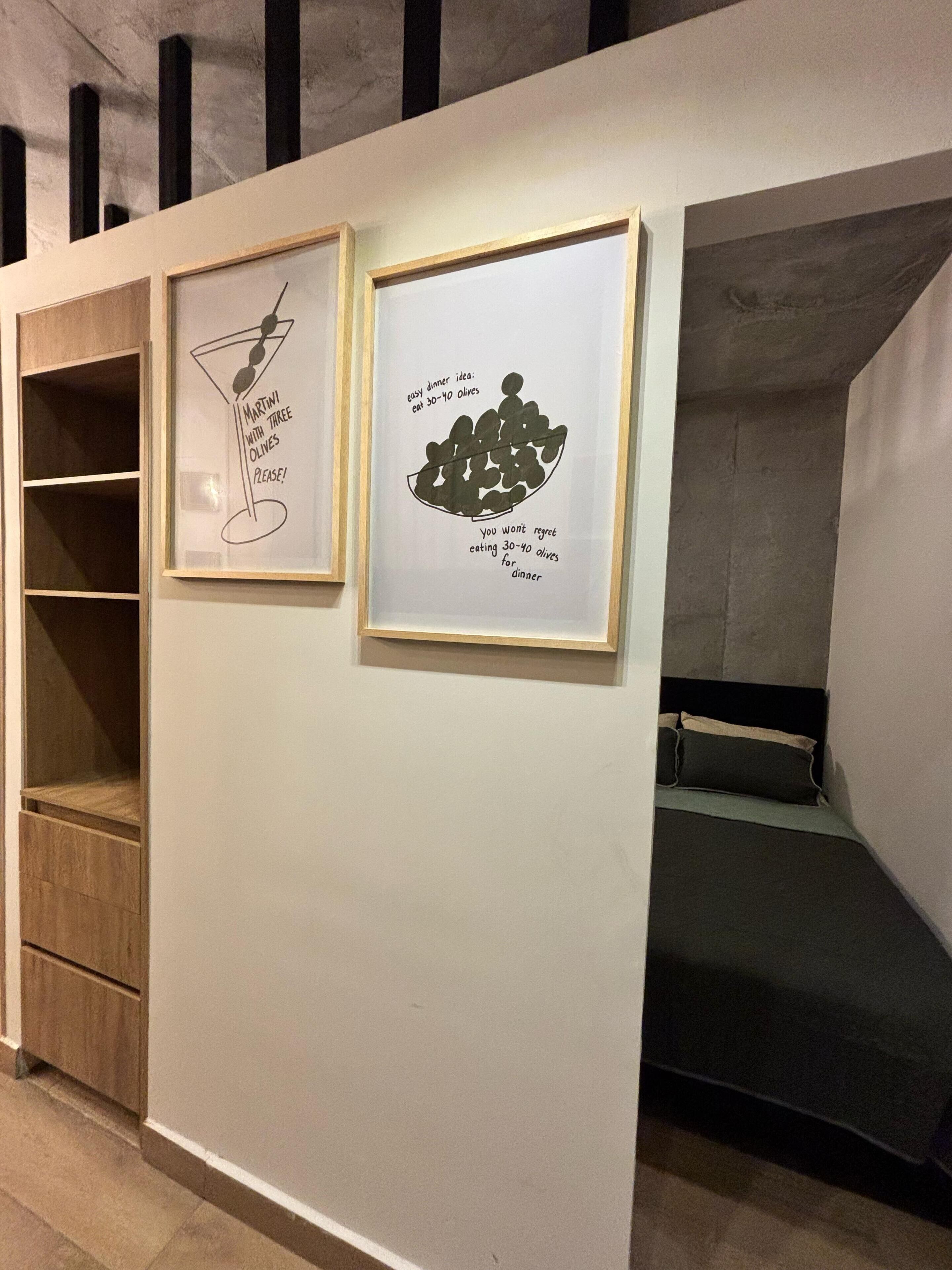 A bunk bed with a small seating area and two framed pictures on the wall.