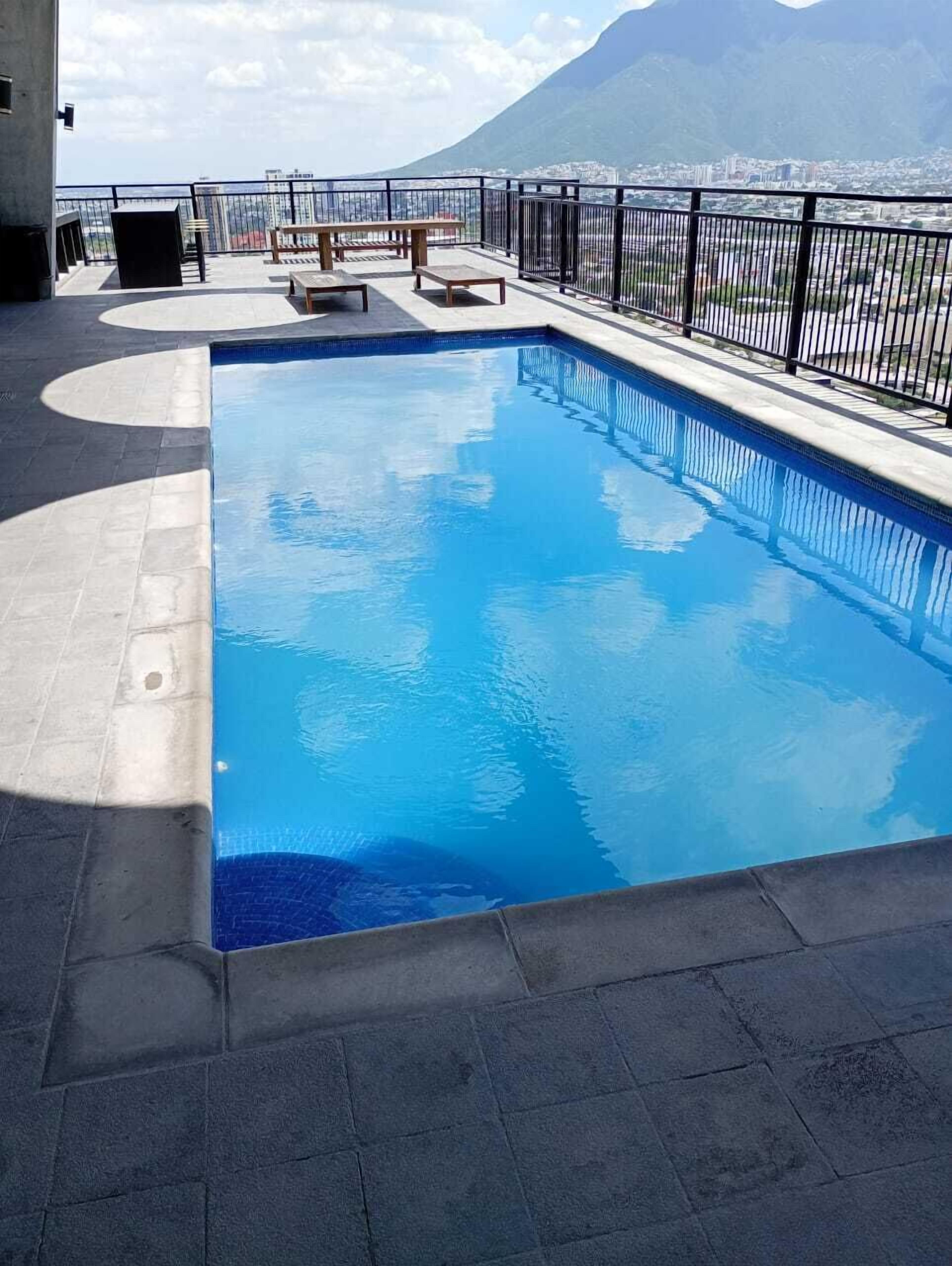 A swimming pool with a view of a mountain and cityscape.