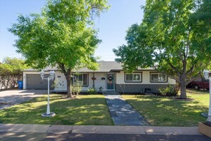 Une maison de plain-pied avec un garage à l’avant, une véranda et une pelouse.