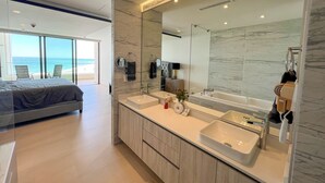A modern bathroom with a large mirror, two sinks, and a bathtub. - Barcelona 307 Ocean Front Brand New 3-bedroom condo. WiFi in lovely Las Palomas (Puerto Peñasco)