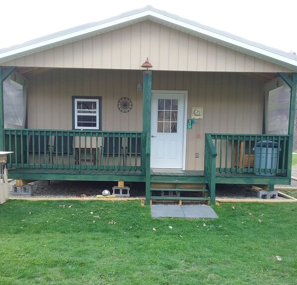 A single-story building with a porch, a door, and a window.