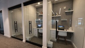 A modern office space with glass partitions, white desks, and built-in shelving. - Ski-Access  2 Queen Beds  Private Patio  Hot Tub (Park City)