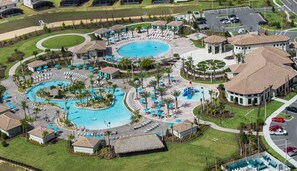 Un resort con varias piscinas, zonas de descanso y un pabellón central.