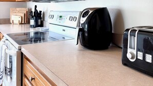 Une cuisine équipée de meubles en bois, d’un four à micro-ondes, d’une cuisinière, d’une machine à café et d’un grille-pain.