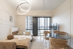 Una habitación de hotel moderna con una cama, una mesa de comedor y un televisor.