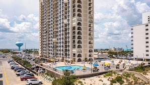 A high-rise hotel with a pool area, multiple balconies, and a view of the beach. - 2 Bedroom Ocean View Condo with Outdoor Pool! (Ocean City)