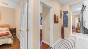 A bedroom with a wooden bed, a nightstand, and a door leading to another room. - Amazing Columbus Circle & Central Park 3-Bedroom by ~ Queen Beds ~By Metro ~ W/D (New York)