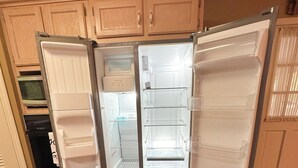 A kitchen with a built-in refrigerator, wooden cabinets, and a microwave.